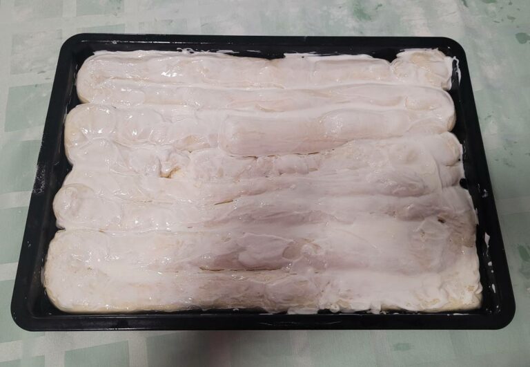 Strudel bestrichen mit Sahne im Backform.