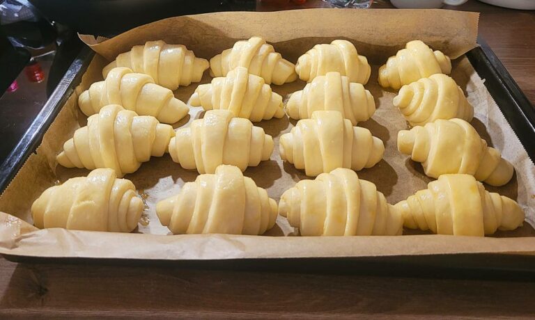 Bestrichene Brötchen in einer Backform.