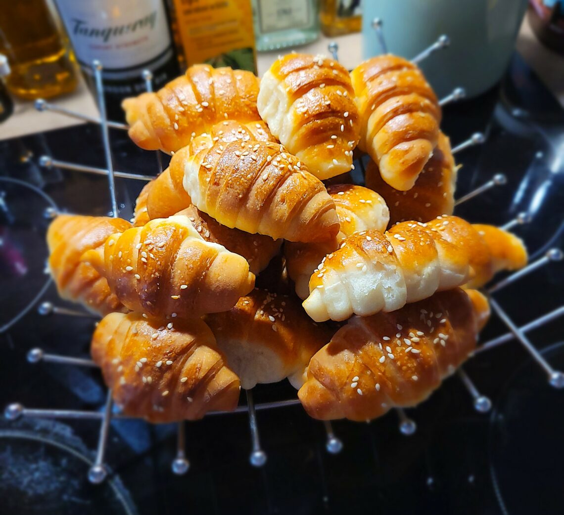 Brötchen mit Sesam in einer Metallschale.