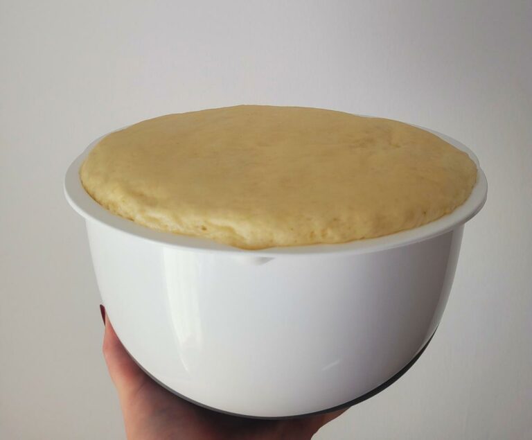 Der aufgegangene Teig in einer weißen Schüssel.