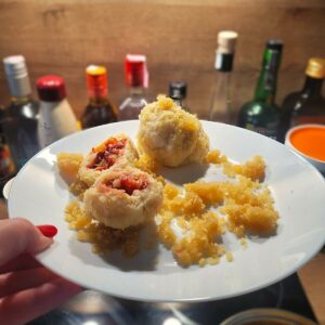 Zwetschgenknödel auf einem weißen Teller.