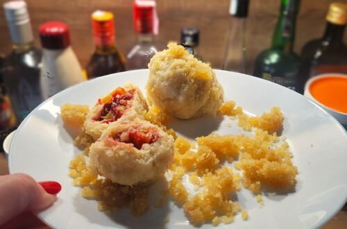 Zwetschgenknödel auf einem weißen Teller.