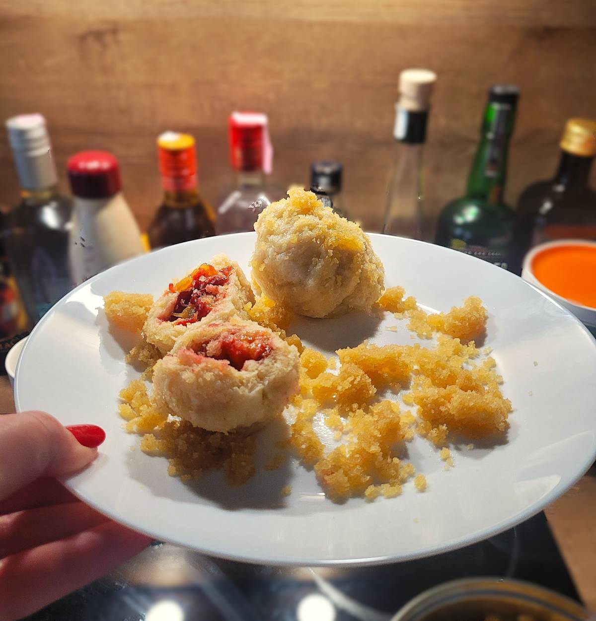 Zwetschgenknödel auf einem weißen Teller.